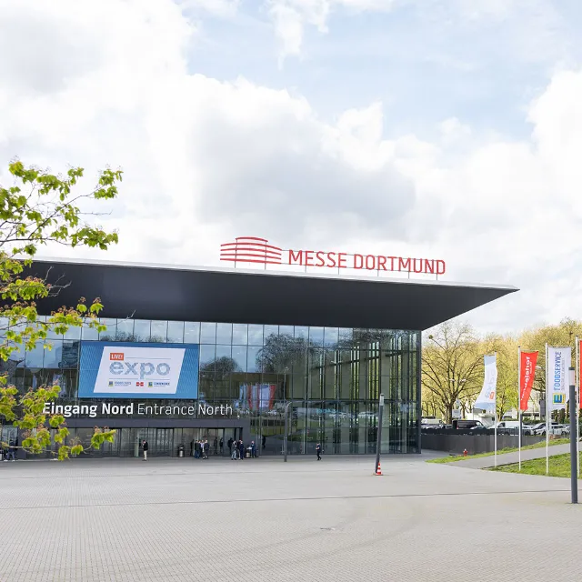 Eingang der Live! EXPO Messe in Dortmund mit wehenden Fahnen von EDEKA Foodservice und Handelshof